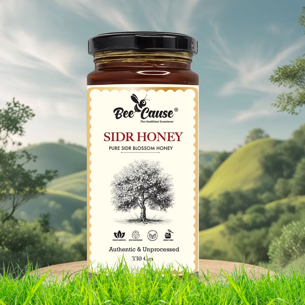 A 330g jar of Bee Cause authentic and unprocessed Sidr Honey sitting on a wooden stump. The foreground features bright green grass, and the background shows a scenic landscape of rolling green hills under a partly cloudy sky.