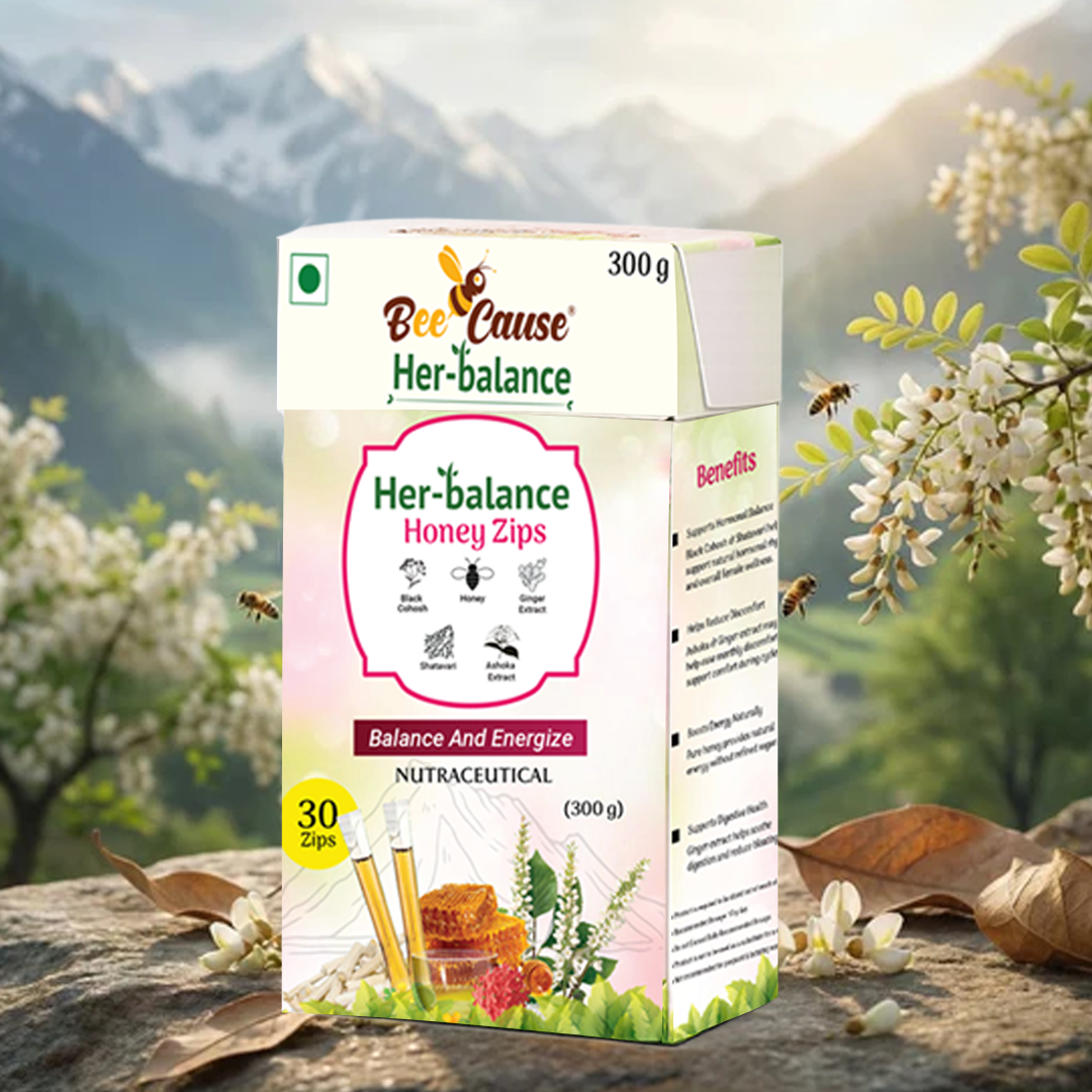 A 300g box of Bee Cause Her-balance Honey Zips resting on a stone surface outdoors. The packaging highlights the phrase "Balance And Energize," lists natural herbal extracts, and shows images of honeycomb and individual honey sticks. The box is set against a serene background featuring majestic mountains, lush green valleys, blooming white flowers, and bees flying in the warm sunlight.