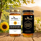 Two jars of honey from Bee Cause with a natural background featuring flowers and trees.