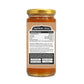 Back view of a glass jar of honey with a gold lid and a brown kraft-style label showing the ingredients and nutrition facts.