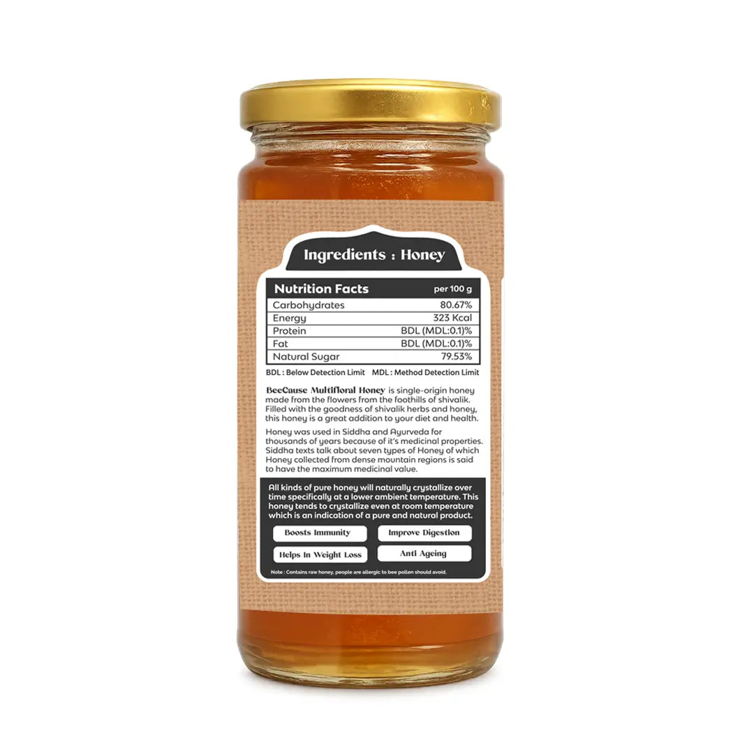 Back view of a glass jar of honey with a gold lid and a brown kraft-style label showing the ingredients and nutrition facts.
