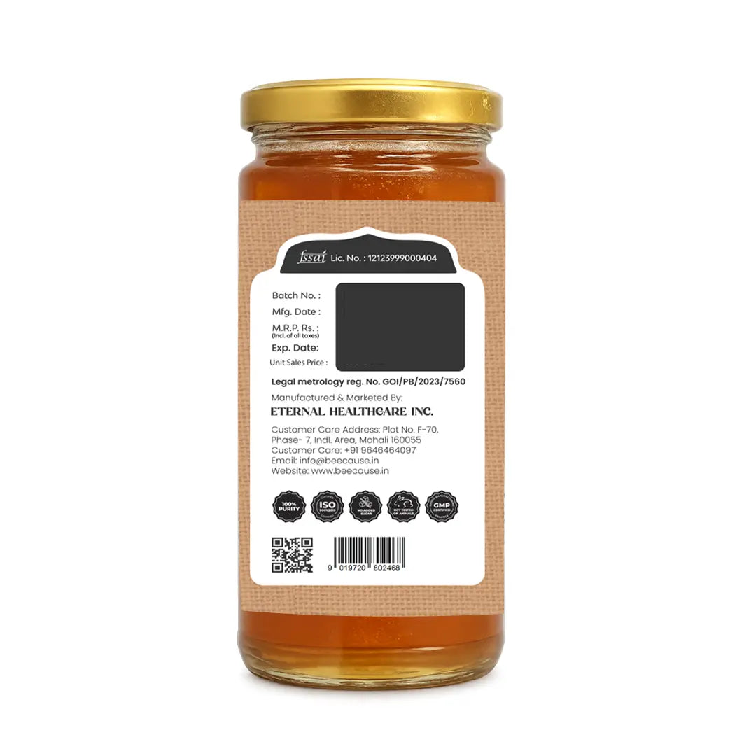 A glass jar of honey with a gold metal lid and a white label showing product details, photographed against a plain white background.
