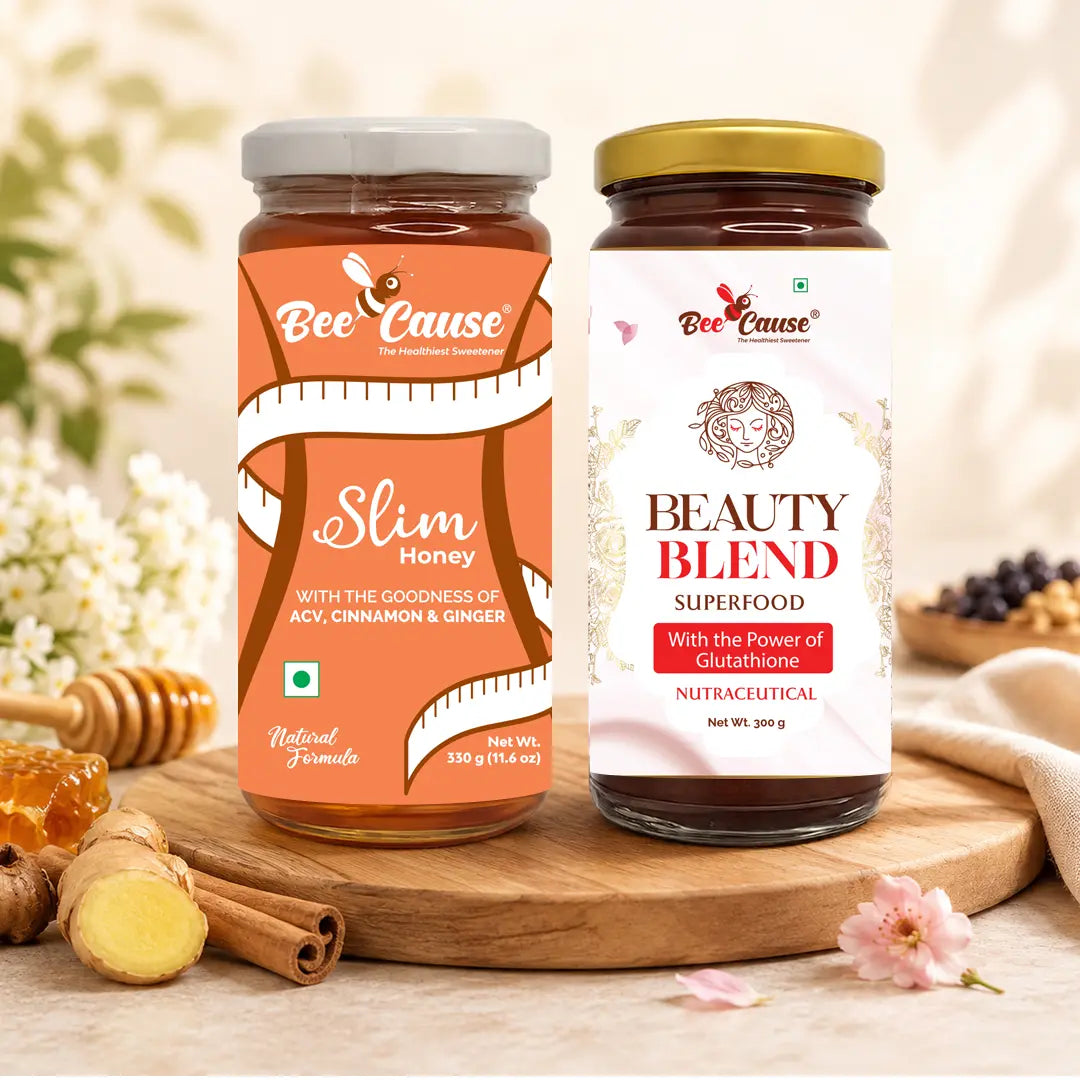 Two jars of 'Bee Cause' honey on a wooden board with flowers and honeycomb in the background.