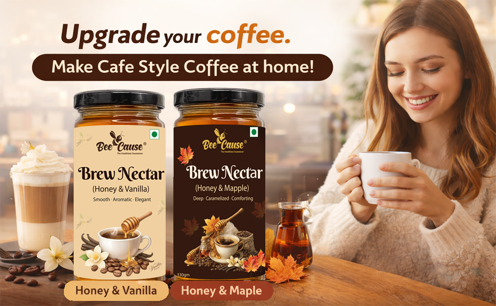 Two jars of Bee Cause Brew Nectar coffee flavor syrups (Honey & Vanilla and Honey & Maple) displayed on a wooden table next to a woman holding a cup of coffee in a cozy cafe setting.