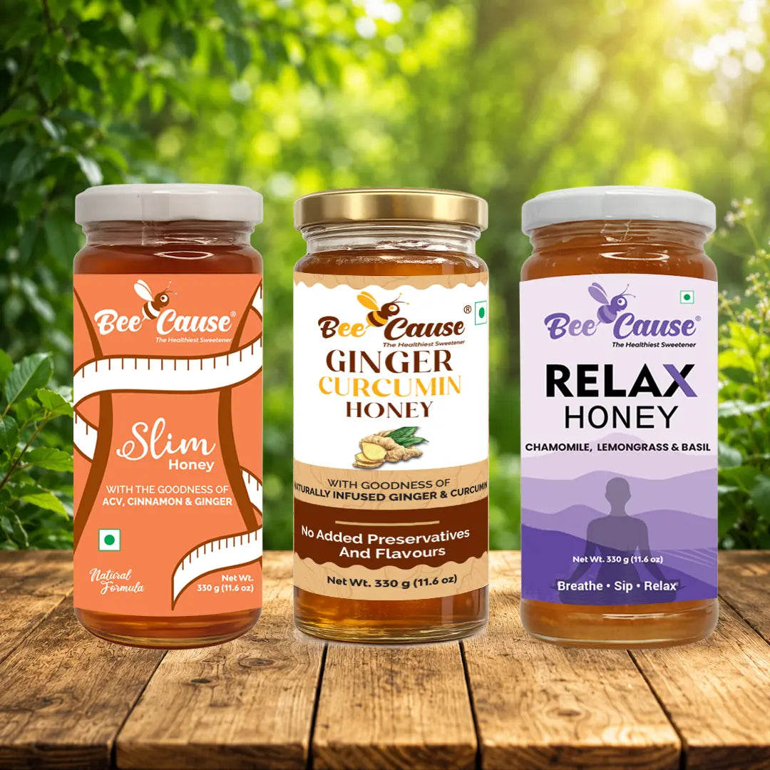 Three jars of 'Bee Cause' honey with different flavors on a wooden surface with a natural background.