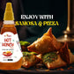 A bottle of Bee Cause Hot Honey Sauce displayed next to a black plate filled with steaming, glazed spicy chicken chunks garnished with green chilies. Text at the top reads "Where Honey Meets Heat" alongside bullet points emphasizing "Made with Pure Honey" and "Perfect for Wings, Grilled & Fried Chicken".