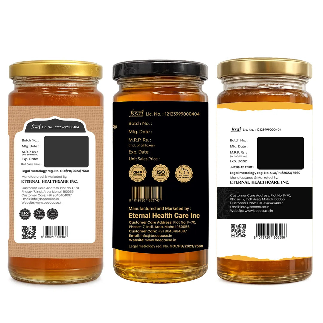 Three glass jars of honey shown from the front, back, and side on a plain white background. The center jar is labeled front-facing with a black label and gold lid, while the left and right jars show the back and side views with white labels and gold lids.