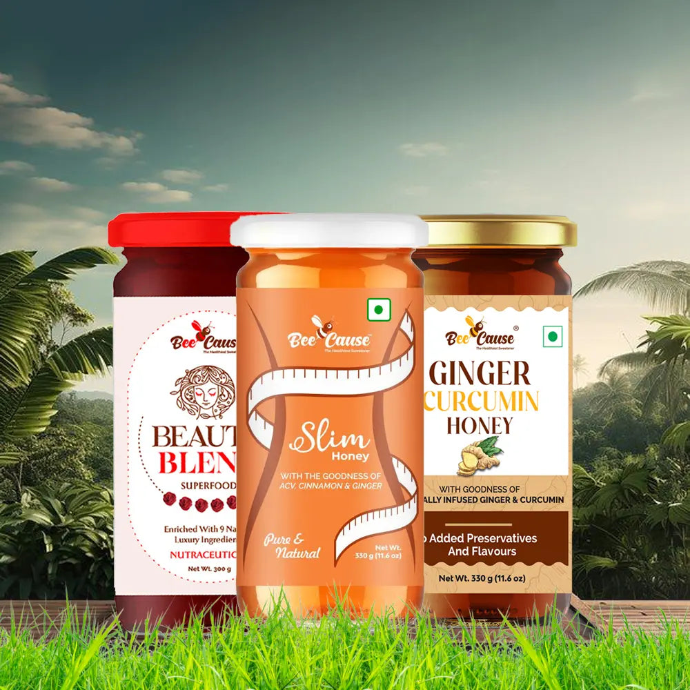 A scenic product display of the Bee Cause Lifestyle Pack featuring Beauty Blend Superfood, Slim Honey, and Ginger Curcumin Honey set against a lush green forest background.