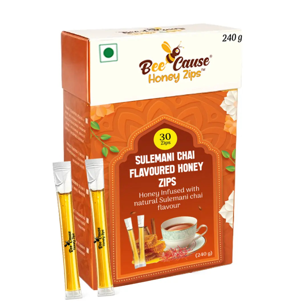 A 240g box of Bee Cause Sulemani Chai Flavoured Honey Zips containing 30 sachets, with two individual honey sticks leaning against the front of the bright orange packaging.
