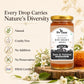 A jar of Bee Cause Raw Golden Honey displayed on a wooden slice with honeycomb and white flowers. The left side features marketing text and icons highlighting key qualities: Natural, Cruelty Free, No Additives, No Preservatives, and FSSAI Certified.