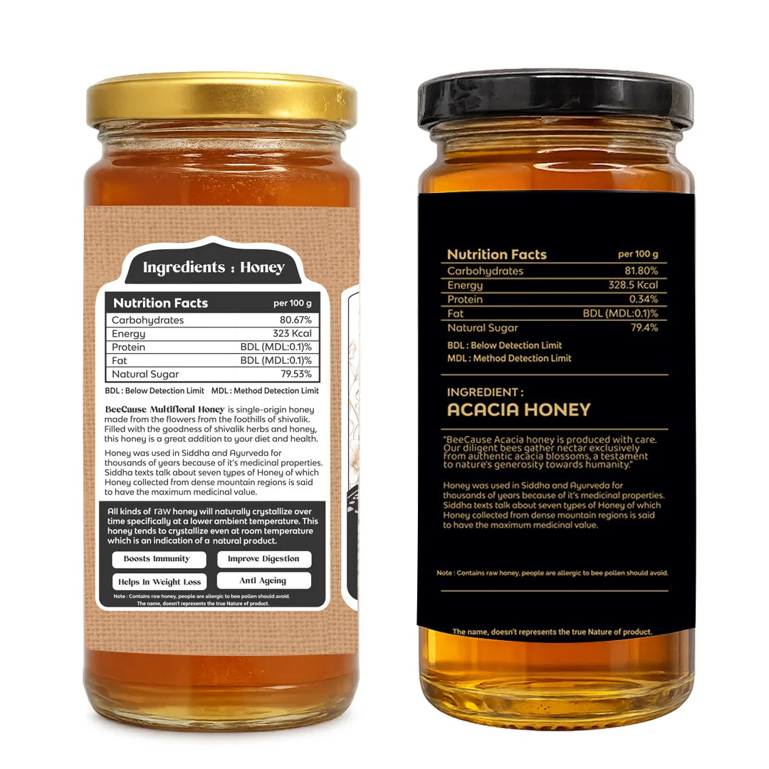Two glass jars of Acacia Honey shown side by side on a white background, displaying the front label with a black lid and the back label with a gold lid.