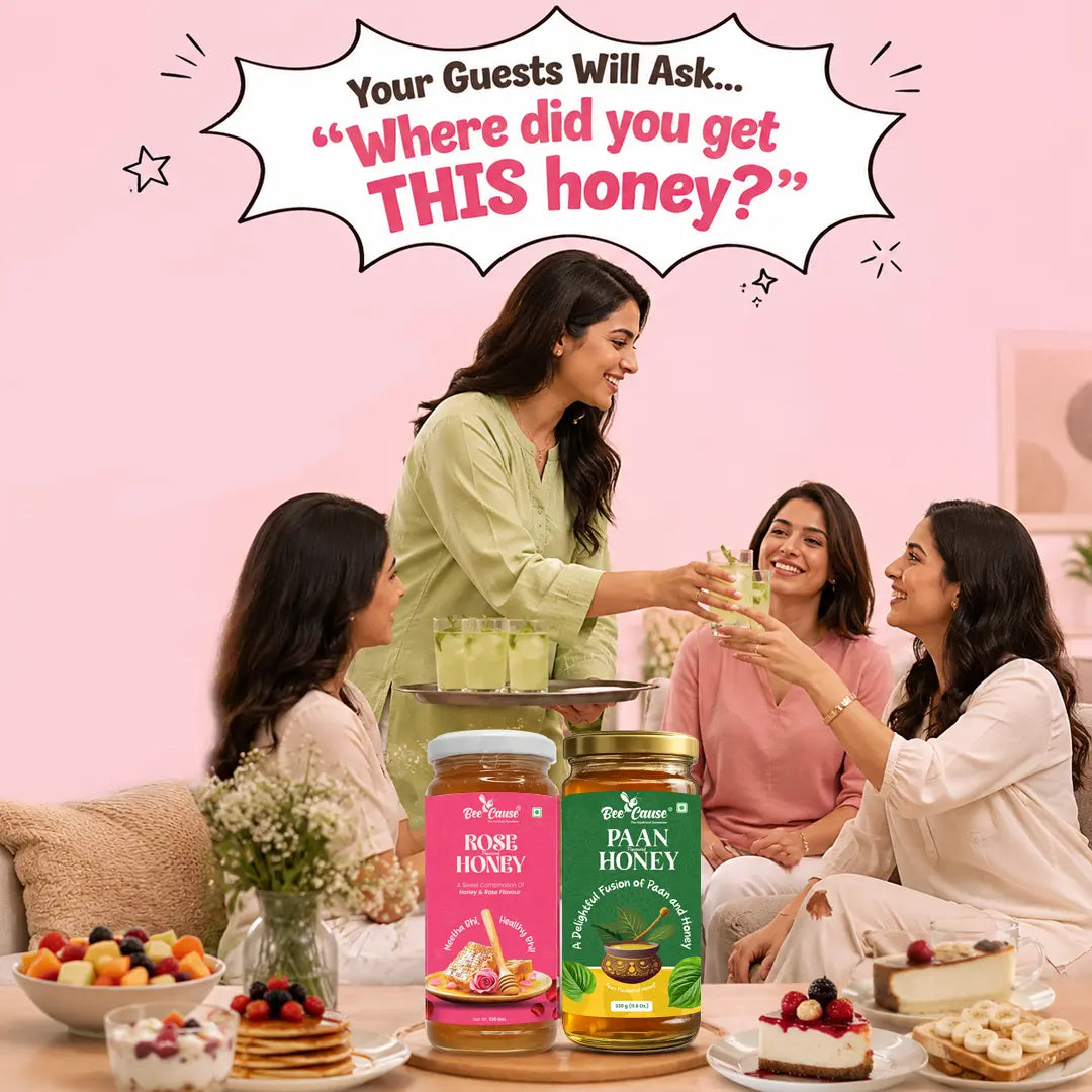 Three women gathered around a table in a bright pink room, smiling and holding honey jars. Two large jars of Mantrajun Honey are prominently displayed on the table, labeled 'Home Honey' in pink and 'Plain Honey' in green.