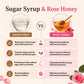 An infographic comparison graphic titled 'Sugar Syrup & Rose Honey' on a light cream background. It features a glass bowl of clear liquid labeled 'SUGAR SYRUP' on the left and a glass bowl of golden honey with a wooden dipper and pink roses labeled 'ROSE HONEY' on the right.