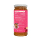 A glass jar of honey drink mix with a white lid and a bright pink label, shown on a plain white background. The label features a nutrition facts section, an ingredients list, and a recipe box with an illustration of a prepared drink.