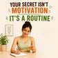 A woman in a sage green tank top sits at a desk writing in a notebook and holding a glass of tea, with motivational text above reading 'YOUR SECRET ISN'T MOTIVATION IT'S A ROUTINE'.